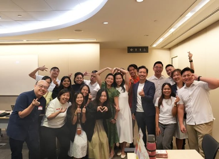 Young PAP members gathered together, making heart gestures with their hands.
